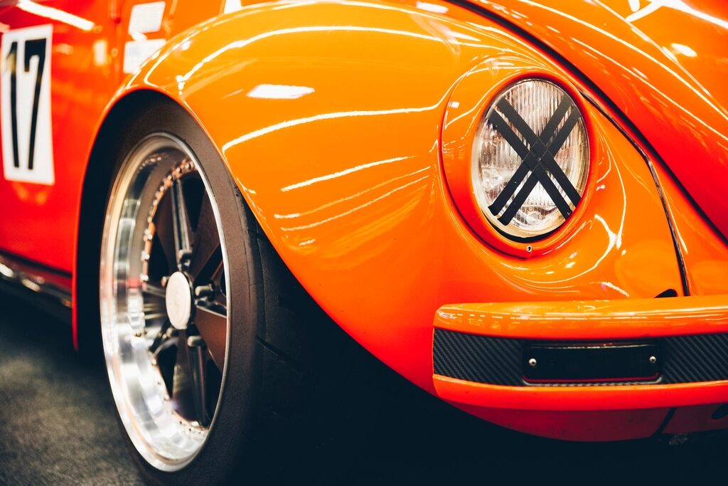 Polished orange paint and chrome wheel on a vintage car