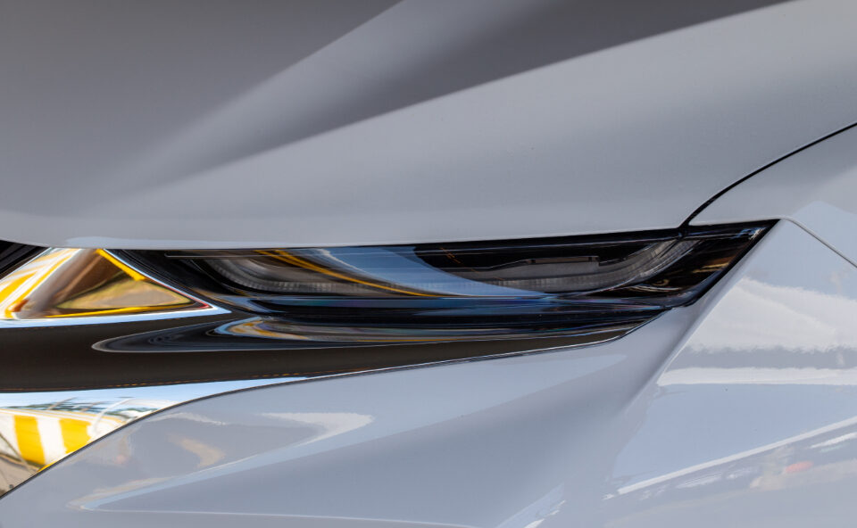 Close view of a silver car headlight and paint