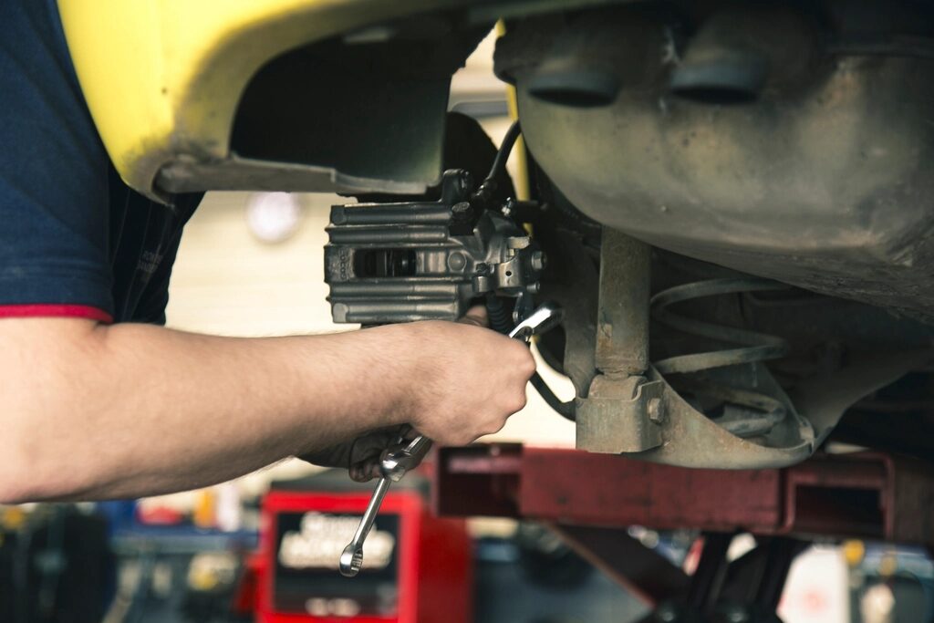 Mechanic working beneath a raised vehicle