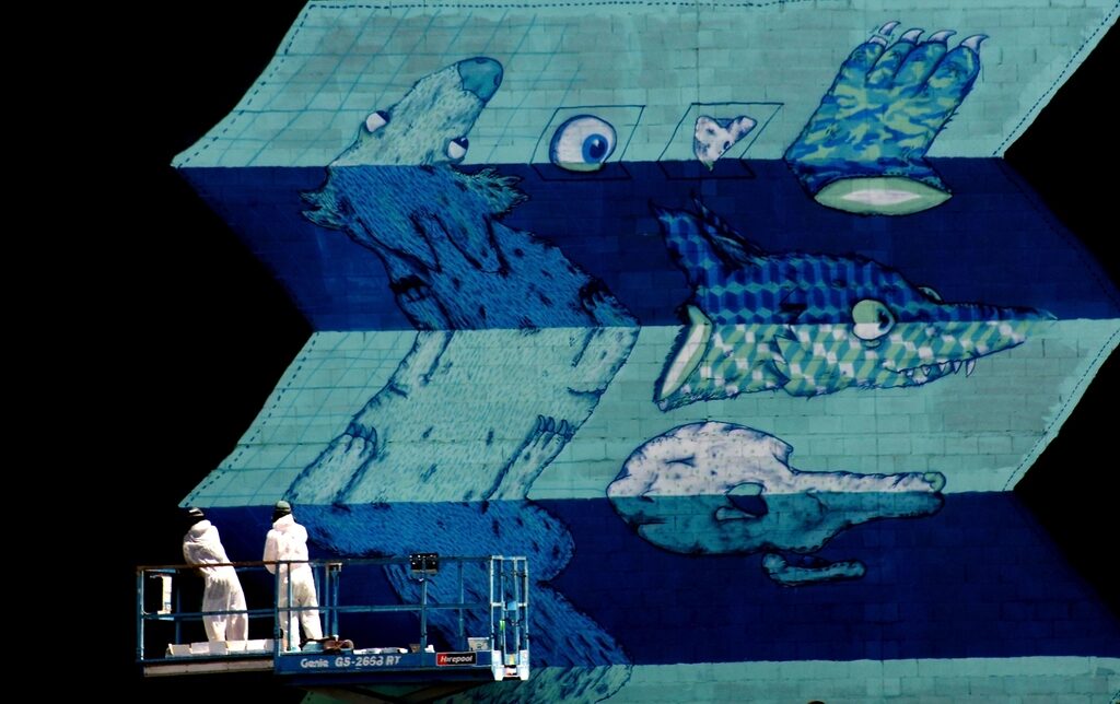 Painters on a lift working on a large mural